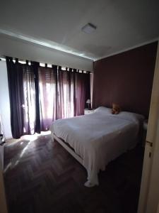 Mar del Plata house في مار ديل بلاتا: غرفة نوم مع سرير مع دمية دب عليها