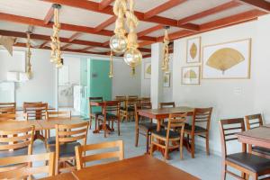 a dining room with wooden tables and chairs at Pousada Antonella in Maragogi