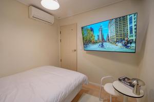 a bedroom with a bed and a flat screen tv on the wall at Wayhome Gasan in Seoul