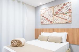 two beds in a bedroom with a painting on the wall at Pousada Antonella in Maragogi