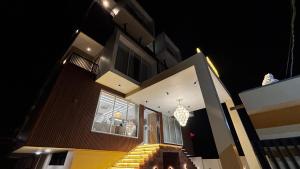 een huis 's nachts met een kroonluchter bij Travinities Hotel Shree Ji Palace in Ujjain