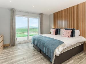 a bedroom with a large bed with a large window at High Tide - Uk44283 in Gatehouse of Fleet