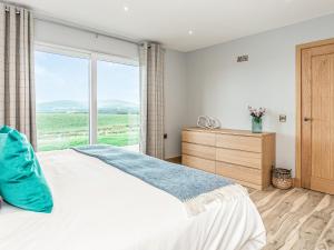 a bedroom with a bed and a large window at High Tide - Uk44283 in Gatehouse of Fleet