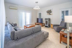 Seaview Villa Selenia pool & jacuzzi in Neo Chorio في نيو تشوريو: غرفة معيشة مع أريكة وتلفزيون