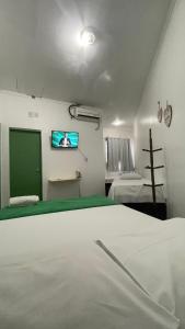 Pôrto da FôlhaにあるPousada Portofolhenseのベッド1台と壁掛けテレビが備わる客室です。 +11枚の写真