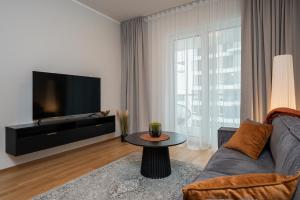 a living room with a couch and a tv at Cosy River Suite in Tartu