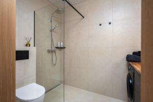 a bathroom with a shower stall and a toilet at Cosy River Suite in Tartu +4 photos