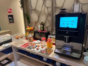 a room with a table with food and a television at Hotel Real in Cinisello Balsamo