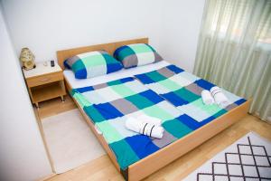 a bedroom with a bed with striped sheets and pillows at Unit Stay Mostar in Mostar