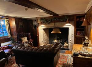 a living room with a leather couch and a fireplace at The Bugle Coaching Inn in Yarmouth +14 photos