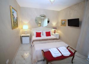 a bedroom with a bed with red pillows and a mirror at B&B Villa Mamma Rita in Tortora