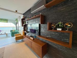 Una sala de estar con televisión y una pared de ladrillos. en Marina Smir Port Luxury 2BR - Seaview - Beachfront, en Marina Smir