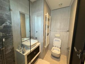 Un baño con inodoro, lavabo y ducha. en Marina Smir Port Luxury 2BR - Seaview - Beachfront, en Marina Smir 34 fotos más