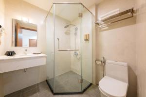a bathroom with a shower and a toilet and a sink at Dolphin Bay Hotel Nha Trang in Nha Trang +43 photos