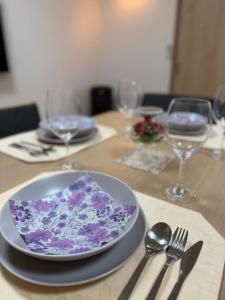 a table with a plate with purple flowers on it at MY HOUSE たいみんぐ kuwana 長島15分 名古屋20分 桑名駅徒歩3分 in Kuwana
