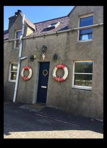 een huis met twee kransen aan de zijkant ervan bij Fisherman's Cottage in Orkney