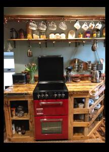 een keuken met een rode kachel en een aanrecht bij Fisherman's Cottage in Orkney