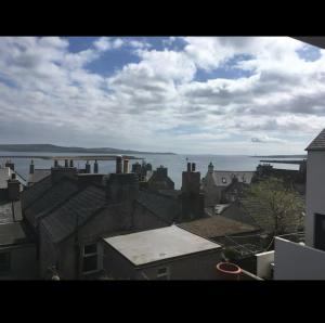 a view of roofs of houses and the water at Fisherman's Cottage in Orkney +3 photos