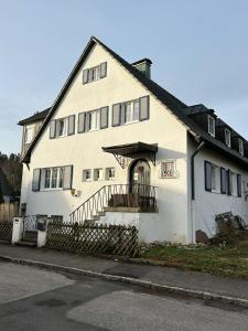 a large white house with a staircase in front of it at Ferienwohnung Palmenwald in Freudenstadt