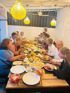 Induwara Villa في أهونغالا: مجموعة من الناس يجلسون على طاولة طويلة يأكلون الطعام