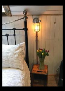 een vaas met bloemen op een tafel naast een bed bij Fisherman's Cottage in Orkney +3 foto's