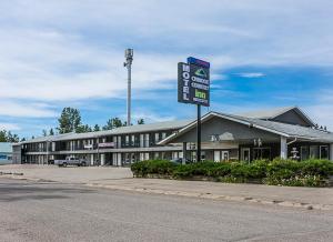 een groot gebouw met een bord ervoor bij Chinook Country Inn in Sundre
