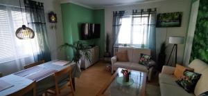 a living room with green walls and a table and chairs at Ferienwohnung Palmenwald in Freudenstadt