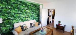 a living room with a green leafy wall at Ferienwohnung Palmenwald in Freudenstadt +15 photos