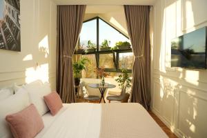a bedroom with a bed and a window and a table at Moonlight Apartments Tirana in Tirana