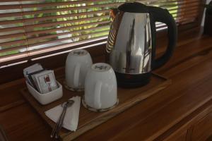 eine Theke mit Kaffeekanne und Tassen darauf in der Unterkunft Villa Diva in Ketewel