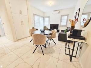 Alexander Residence Trikallon Str في نيقوسيا: غرفة معيشة مع طاولة وكراسي وأريكة
