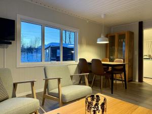 ein Wohnzimmer mit Esstisch und Stühlen in der Unterkunft Hiet- Arctic cabin in the norwegian forrest! in Tromsø