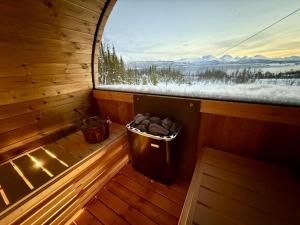 ein Zimmer mit einem Fenster in einer Hütte mit einem Mülleimer in der Unterkunft Hiet- Arctic cabin in the norwegian forrest! in Tromsø