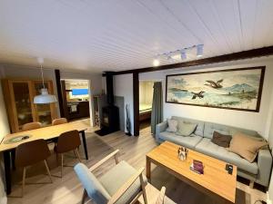 ein Wohnzimmer mit Sofa und Tisch in der Unterkunft Hiet- Arctic cabin in the norwegian forrest! in Tromsø