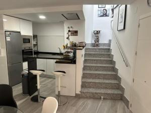 a kitchen with a staircase with stools in front of it at Edificio Resort Gran8Nerja in Nerja