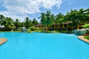 uma grande piscina com palmeiras ao fundo em Pestana Miramar São Tomé em São Tomé