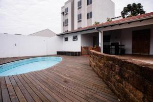 una piscina su una terrazza in legno accanto a un edificio di Casa ampla e confortável a Lajeado