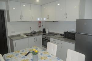 a kitchen with white cabinets and a table with flowers on it at Casas da Travessoa in Marco de Canaveses