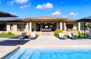 een villa met een zwembad en een huis bij A Liccia in Pianottoli-Caldarello