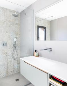 een badkamer met een witte wastafel en een spiegel bij A Liccia in Pianottoli-Caldarello