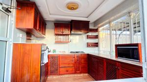 a kitchen with wooden cabinets and a counter top at Serenity Gardens,pool retreat, Kigamboni in Dar es Salaam