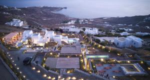 an aerial view of a city at night with lights at Collini Hotel Mykonos, WorldHotels Elite in Fanari
