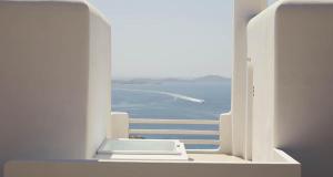 a view of the ocean from a white window at Collini Hotel Mykonos, WorldHotels Elite in Fanari