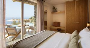 a bedroom with a bed and a view of the ocean at Collini Hotel Mykonos, WorldHotels Elite in Fanari +58 photos