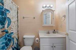 a bathroom with a toilet and a sink and a mirror at 235 E Spicer Ave, Unit A in Wildwood +23 photos