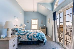 a bedroom with blue walls and a bed and a window at 235 E Spicer Ave, Unit A in Wildwood
