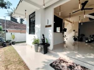 a white house with potted plants on the floor at One Love in Weligama