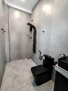 a bathroom with a black toilet and a sink at One Love in Weligama +30 photos