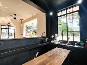 a large kitchen with a wooden table and windows at One Love in Weligama