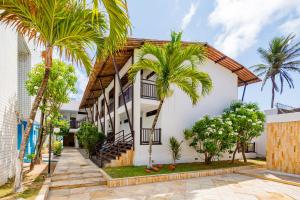 a house with palm trees in front of it at Sirius Beach Hotel in Natal